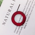 Close-up of a red geometric wooden ring pendant with natural grain on a minimal white card - Red