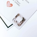 Macro-detail van vierkante acetaat hangers met grijze marmeren textuur voor DIY sieraden - Grijsbruine Marmerstructuur