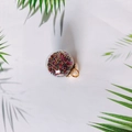 Macro detail of transparent glass ball charms filled with colorful beads and gold loops - Colorful Micro-beads Style