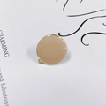 Detail eines hellkaffeefarbenen Emaille-Anhängers mit Goldrand für DIY-Ohrringe - Hellkaffee