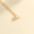 Elegante goldene Edelstahlkette mit einem birnenförmigen weißen Opal-Anhänger - Gold-Oktober