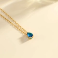 Elegante Goldhalskette mit einem birnenförmigen dunkelblauen Edelsteinanhänger an O-Kette - Gold-Dezember