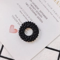 Close-up of black woven circular resin jewelry charms with intricate DIY craft texture - Black