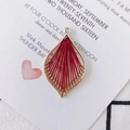 Macro view of gold leaf pendant with red thread weave for DIY jewelry making - Burgundy