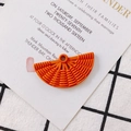 Détail macro du pendentif en résine orange en forme d'éventail avec texture tissée et trou - Orange