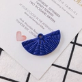 Détail d'une breloque en résine bleue en forme d'éventail avec texture tissée - Bleu