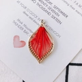 Detail of bohemian red silk thread weaving inside a golden water drop earring pendant - Red
