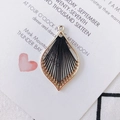 Detailed view of leaf-shaped gold alloy pendant with black woven silk thread crafts - Black