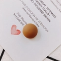 Close-up of matte brown resin circular accessory for DIY projects on white paper - Brown
