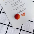 Matte red resin semi-round patch for DIY shoes and crafts on a white wedding invitation - Caramel color