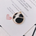 Macro shot of circular faux fur leopard pendant with a polished golden metal frame - White Black Print (4#)