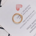 Detailansicht eines doppellagigen goldenen Rings mit gedrehter Seilstruktur auf weichem Stoff - Gold