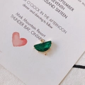 Dettaglio di un connettore a semicerchio con gemma verde e placcatura in oro per gioielli - Verde