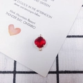 Macro detail of red rhombus crystal pendant in 18k gold plated frame with dual loops - Red