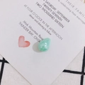 Macro shot of light green teardrop pearl pendant on a white wedding invitation card - Light Green