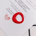 Close-up of red enamel circular charm with gold metal edge for DIY jewelry making - Red