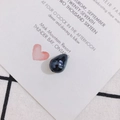 Close-up of a polished dark blue teardrop pearl bead with a pre-drilled hole for DIY jewelry - Black