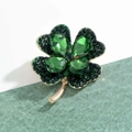 Green four-leaf clover brooch featuring teardrop gemstones and gold metallic stems - Green