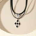 Double-layered black leather cord necklace with waterdrop crystal and checkered pendant - Black