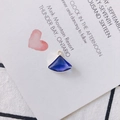 Macro shot of a fan-shaped blue crystal pendant with a gold metal frame for jewelry making - Blue
