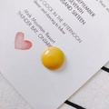Macro shot of bright yellow resin round bead detail on a decorative heart display card - Yellow