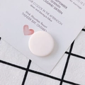 White rubber-coated flat round bead for DIY earrings placed on a stylish invitation card - Pink