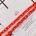 Bright orange resin chain link for DIY necklaces and bags shown on a checkered background - Red