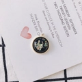 Macro detail of a round shell inlay pendant for DIY jewelry making on card background - Black