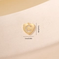 Dettaglio macro del ciondolo a cuore dorato con lettera C e zirconi, misura 1cm - Lettera C-Oro