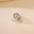 Makroaufnahme einer 0,7cm Silber-Zwischenperle mit Hohlmuster und weißen Zirkoniasteinen - Kreuzgitter-Hohlzylinderperle (MYYX00505)