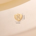 Macro di ciondolo a cuore dorato con lettera K in zircone su sfondo beige materico - Lettera K-Oro