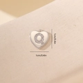 Macro di un ciondolo a cuore argentato da 1 cm con lettera Q in zirconi lucidi - Lettera Q-Platino