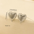 Macro detail of silver heart stud earrings featuring a liquid metal textured surface - Heart-Shaped Brushed Texture Style (MYED34142) / White Gold