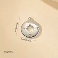 Macro view of a circular compass pendant with zircon inlay and directional engravings - Compass Disk Style (MYXL12018) / White Gold