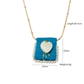 Detail of blue woven rectangle pendant with heart inlay and pearls on a gold chain - Dark Blue Knit Heart Pendant (Bag 4)