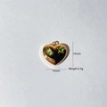 Detail showing 15mm heart pendant size with green stones and polished gold finish - 15mm / Gold Heart With Light Green Stone