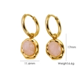 Detalle de pendientes dorados con piedras naturales rosas y bordes estilo lava - Cuarzo Rosa