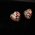 Dettaglio di orecchini a cuore dorati con pietre preziose multicolore su sfondo nero - Cuore Traforato Zirconia Multicolore (ED12522)