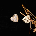 Orecchini a cuore dorati con tre zirconi scintillanti su fondo nero professionale - Cuore a Tre Pietre Zirconia Oro (ED13698)