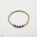 Close-up of golden beaded bracelet featuring four faceted purple and blue crystal charms - Single Beaded Bracelet (YB1015-BLU)