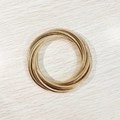 Close-up of golden multi-layer spring-coiled wrap bracelet on light wood texture - Gold YB1091G-5mm