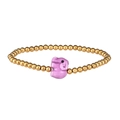Close-up of golden metal beads bracelet featuring a cute pink ceramic elephant charm - Gold Purple Elephant