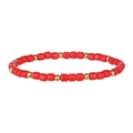 Dettaglio di perline cilindriche rosse e distanziatori dorati su un bracciale boho - Rosso
