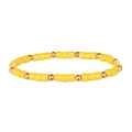 Dettaglio di cilindri in resina gialla e perle metalliche dorate sul bracciale elastico - Giallo