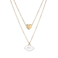 Detail of layered gold necklace featuring a 3D heart and white enamel lip pendant - Gold White