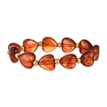 Dettaglio delle perle a cuore in resina ambrata e sfere dorate su un bracciale vintage - Perline di Resina a Cuore Ambra