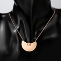 Détail d'un collier en titane or rose avec pendentif géométrique sur un buste noir - Or Rose (Pendentif en Forme de Éventail)
