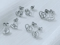 Detail view of heart-shaped stainless steel zodiac stud earrings with cancer and leo signs - Taurus / Steel