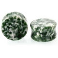Vue macro des écarteurs en pierre verte avec texture marbrée et design de type selle - Jade de Qinghai