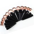 Detail view of acrylic tapers and rose gold steel tunnels set for ear stretching - Black Taper Set / Rose Gold